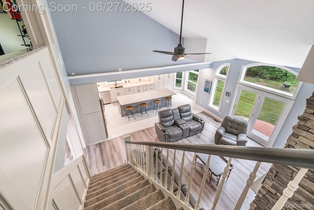 5408 N Seymour Rd, Flushing, MI 48433 - staircase featuring wood finished floors, ceiling fan, and high vaulted ceiling