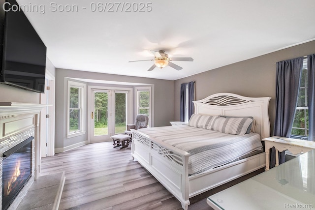 5408 N Seymour Rd, Flushing, MI 48433 - bedroom featuring access to exterior, light wood-style flooring, a tile fireplace, and ceiling fan