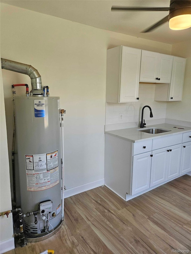 23723 Vassar Ave, Hazel Park, MI 48030 - kitchen featuring water heater, light wood-style floors, white cabinets, light countertops, and a ceiling fan