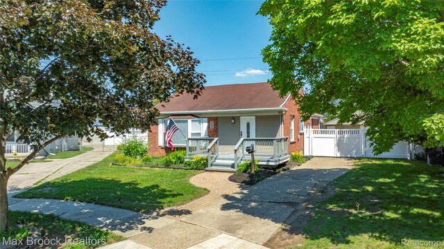 1122 Symes Ct, Royal Oak, MI 48067 - obstructed view of property with a porch, concrete driveway, brick siding, a gate, and a garage
