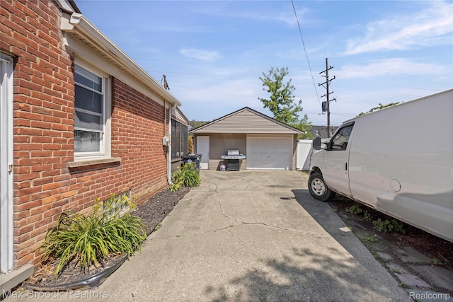 1122 Symes Ct, Royal Oak, MI 48067 - view of home's exterior with brick siding, an outdoor structure, a detached garage, and concrete driveway