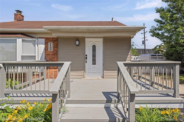 1122 Symes Ct, Royal Oak, MI 48067 - entrance to property featuring brick siding, a chimney, and roof with shingles