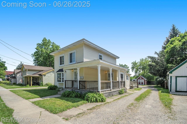 207 Washington St, Holly, MI 48442 - view of front of home with covered porch, a storage unit, and driveway