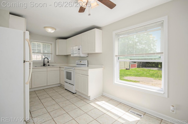 207 Washington St, Holly, MI 48442 - kitchen featuring white appliances, light tile patterned flooring, light countertops, and white cabinetry