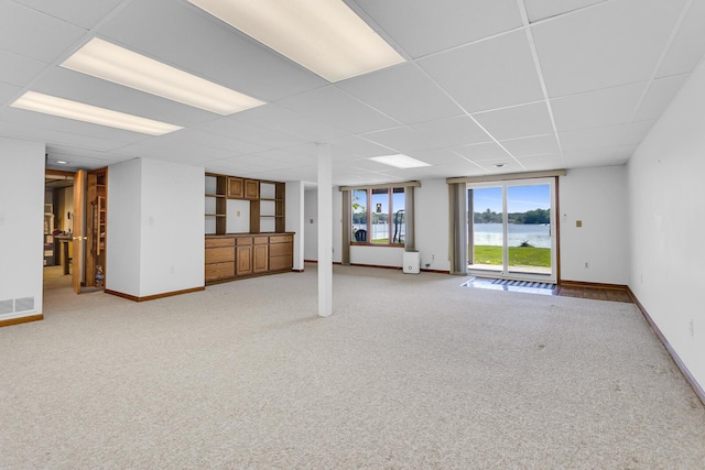 38 Evans Trl, Tipton, MI 49287 - unfurnished living room featuring a water view, light colored carpet, and a drop ceiling