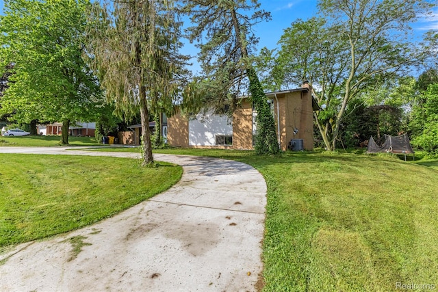 2738 Berry Dr, Bloomfield Hills, MI 48304 - view of front of home with a trampoline, a front yard, curved driveway, and a chimney