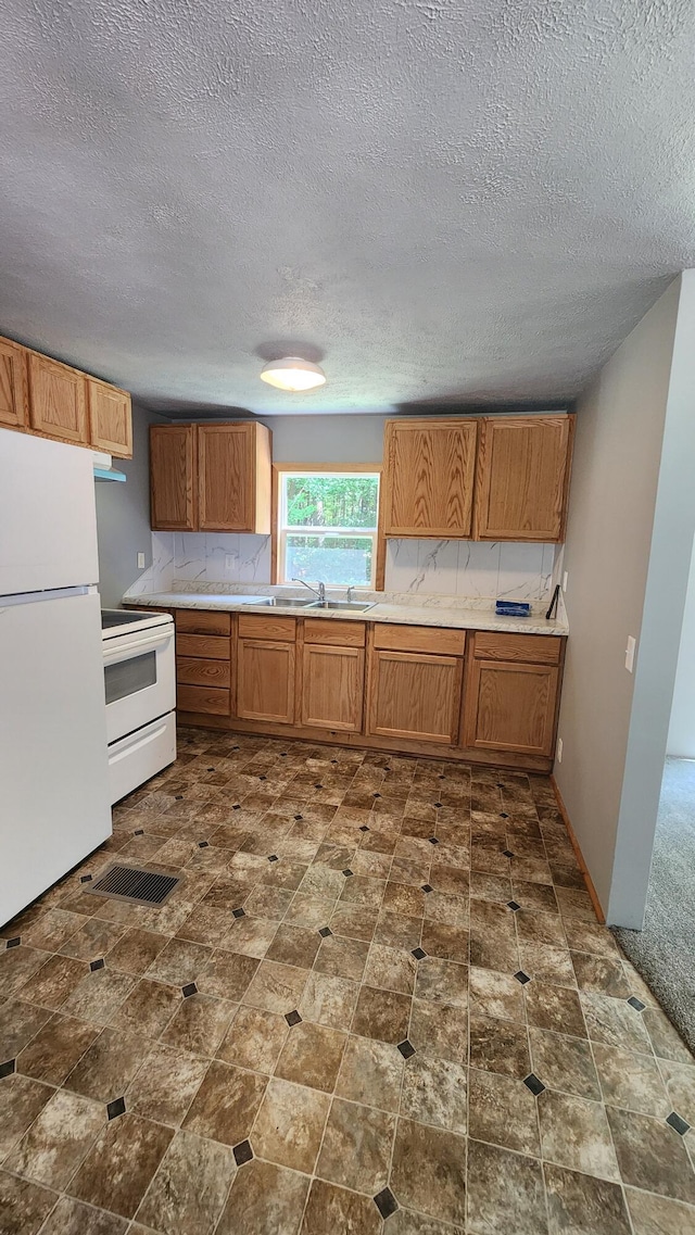 5213 S Newcosta Ave, Newaygo, MI 49337 - kitchen with white appliances, brown cabinets, a textured ceiling, and light countertops