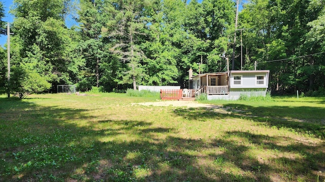 5213 S Newcosta Ave, Newaygo, MI 49337 - view of grassy yard with a porch and a wooded view