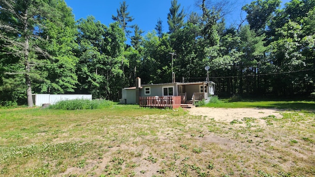 5213 S Newcosta Ave, Newaygo, MI 49337 - view of green lawn with a wooden deck and a view of trees
