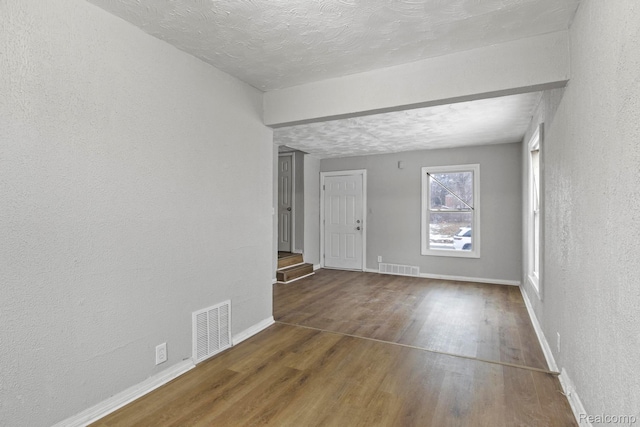 9110 Mansfield St, Detroit, MI 48228 - empty room featuring wood finished floors, a textured wall, and a textured ceiling