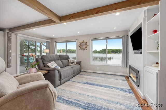 12865 S Englewright Dr, Sand Lake, MI 49343 - living area featuring recessed lighting, light wood-style flooring, beam ceiling, and a glass covered fireplace