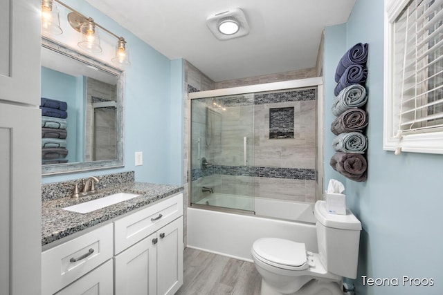 12865 S Englewright Dr, Sand Lake, MI 49343 - bathroom featuring vanity, enclosed tub / shower combo, and wood finished floors