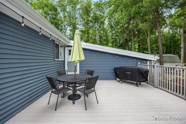 12865 S Englewright Dr, Sand Lake, MI 49343 - wooden terrace with outdoor dining area, area for grilling, a shed, and view of wooded area