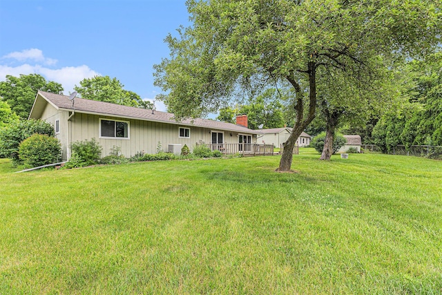 8025 Fosdick Rd, Saline, MI 48176 - back of property with a lawn, a chimney, board and batten siding, and a deck