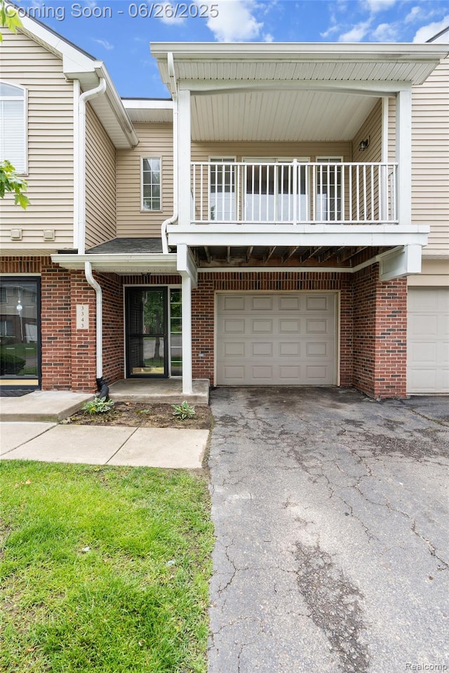 3343 Northpointe Blvd, Melvindale, MI 48122 - view of front facade featuring a balcony, an attached garage, asphalt driveway, and brick siding