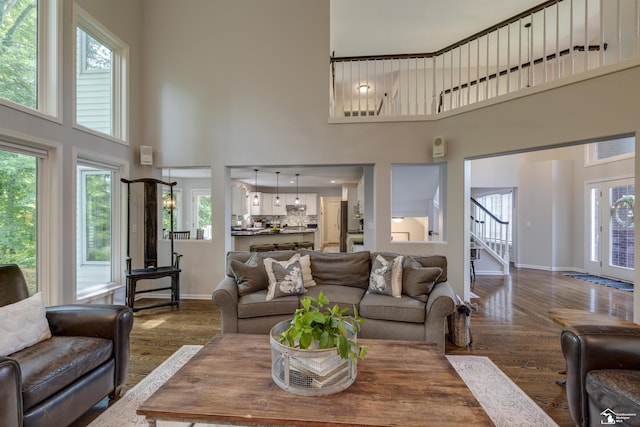 7145 S Valley Cir, Lambertville, MI 48144 - living room featuring a towering ceiling, dark wood-style floors, stairs, and healthy amount of natural light
