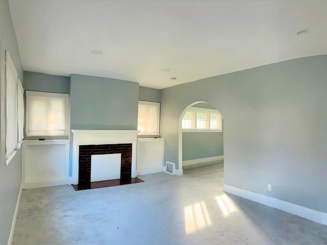 3254 W W Philadelphia St, Detroit, MI 48206 - unfurnished living room featuring a fireplace with flush hearth, carpet, and arched walkways