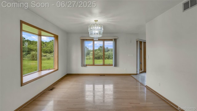 5050 Burton Rd, Capac, MI 48014 - spare room featuring light wood finished floors and a chandelier