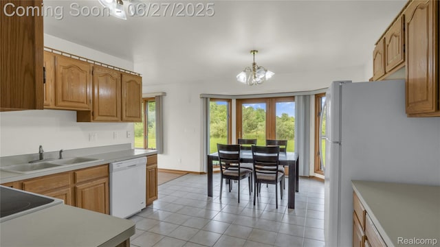 5050 Burton Rd, Capac, MI 48014 - kitchen featuring white appliances, a chandelier, brown cabinets, and hanging light fixtures