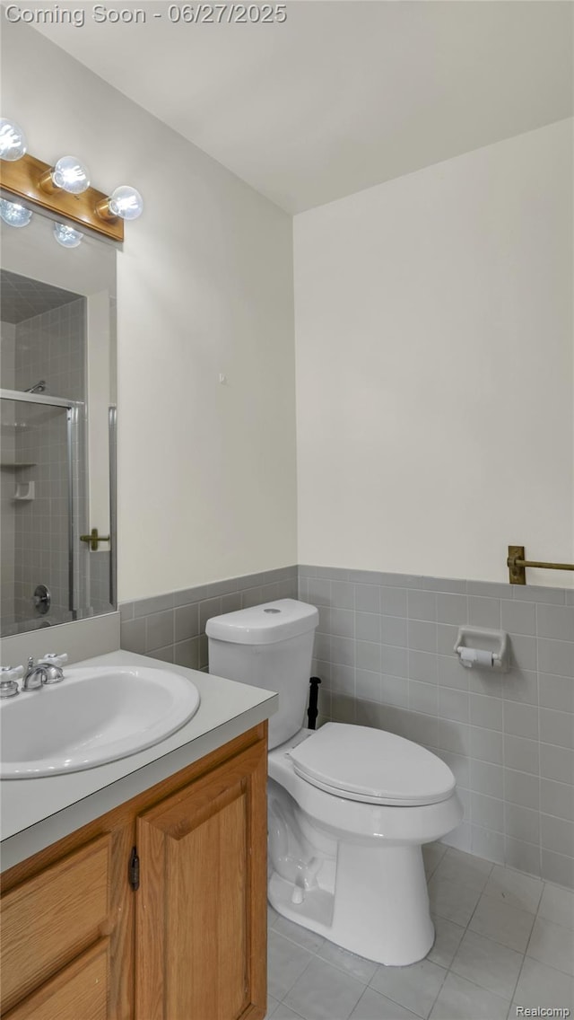 5050 Burton Rd, Capac, MI 48014 - full bathroom featuring tile walls, a shower stall, vanity, tile patterned floors, and a wainscoted wall