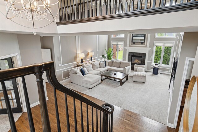 46746 Merion Cir, Northville, MI 48168 - living room with a towering ceiling, a fireplace, a chandelier, and wood finished floors