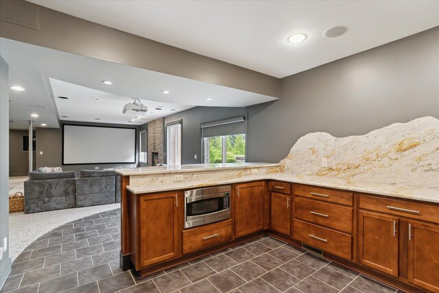 46746 Merion Cir, Northville, MI 48168 - kitchen featuring stainless steel microwave, dark tile patterned flooring, brown cabinets, and open floor plan