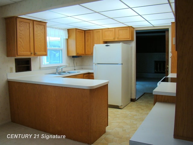 4215 S Wayside Dr, Saginaw, MI 48603 - kitchen with freestanding refrigerator, a peninsula, light countertops, light flooring, and a drop ceiling