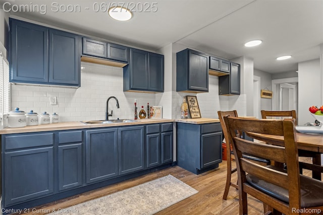3917 Bewick St, Detroit, MI 48214 - kitchen with blue cabinetry, light wood-style flooring, backsplash, and light countertops