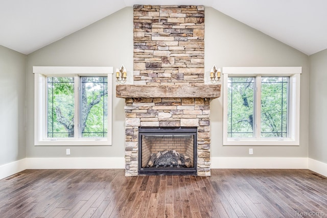 2685 Fry Rd, Highland, MI 48357 - unfurnished living room featuring lofted ceiling, wood-type flooring, a stone fireplace, and healthy amount of natural light