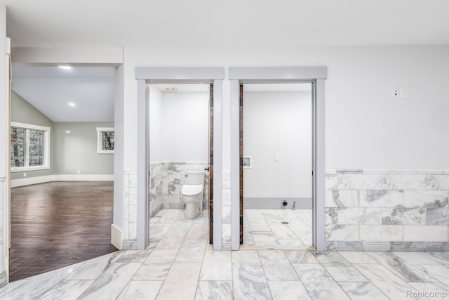 2685 Fry Rd, Highland, MI 48357 - bathroom featuring marble look tiles and wainscoting