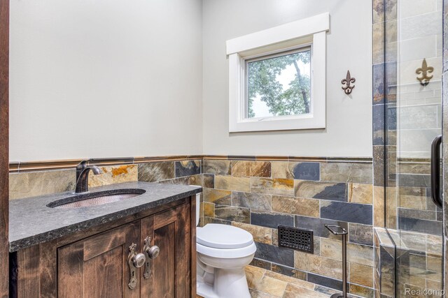 2685 Fry Rd, Highland, MI 48357 - bathroom featuring tile walls, vanity, a wainscoted wall, and stone finish floors