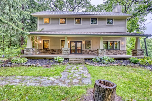 2685 Fry Rd, Highland, MI 48357 - back of house with a porch, a chimney, a standing seam roof, a metal roof, and stone siding