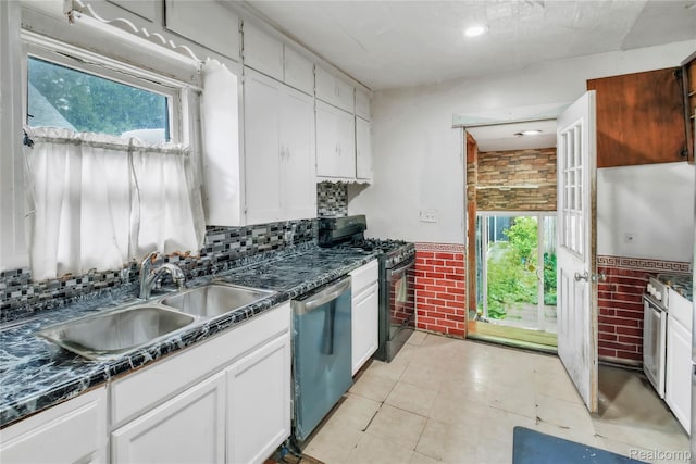 2211 Avon St, Saginaw, MI 48602 - kitchen featuring dishwashing machine, stainless steel gas range oven, dark countertops, white cabinetry, and backsplash