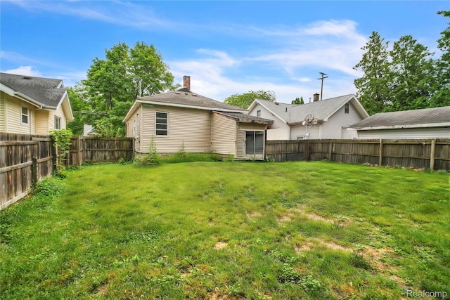 2211 Avon St, Saginaw, MI 48602 - rear view of property with a fenced backyard and a chimney