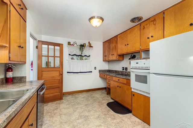 239 Heyn St, Saginaw, MI 48602 - kitchen featuring white appliances, brown cabinetry, and dark countertops