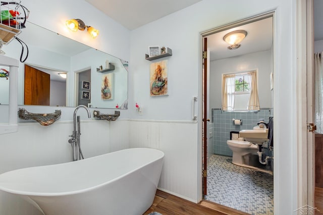 239 Heyn St, Saginaw, MI 48602 - bathroom featuring a freestanding tub, wainscoting, and wood finished floors