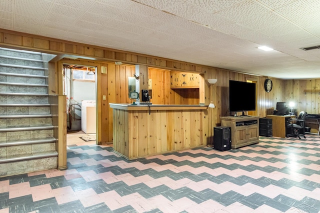 239 Heyn St, Saginaw, MI 48602 - kitchen featuring light floors, washer / dryer, wood walls, and open floor plan