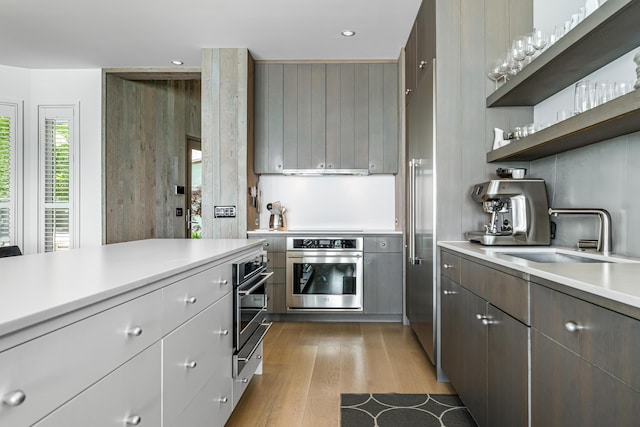 9182 Hemlock Ln, Bridgman, MI 49106 - kitchen with stainless steel oven, wood finished floors, light countertops, open shelves, and recessed lighting