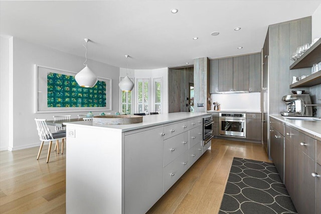 9182 Hemlock Ln, Bridgman, MI 49106 - kitchen featuring stainless steel oven, light wood-style floors, light countertops, open shelves, and recessed lighting