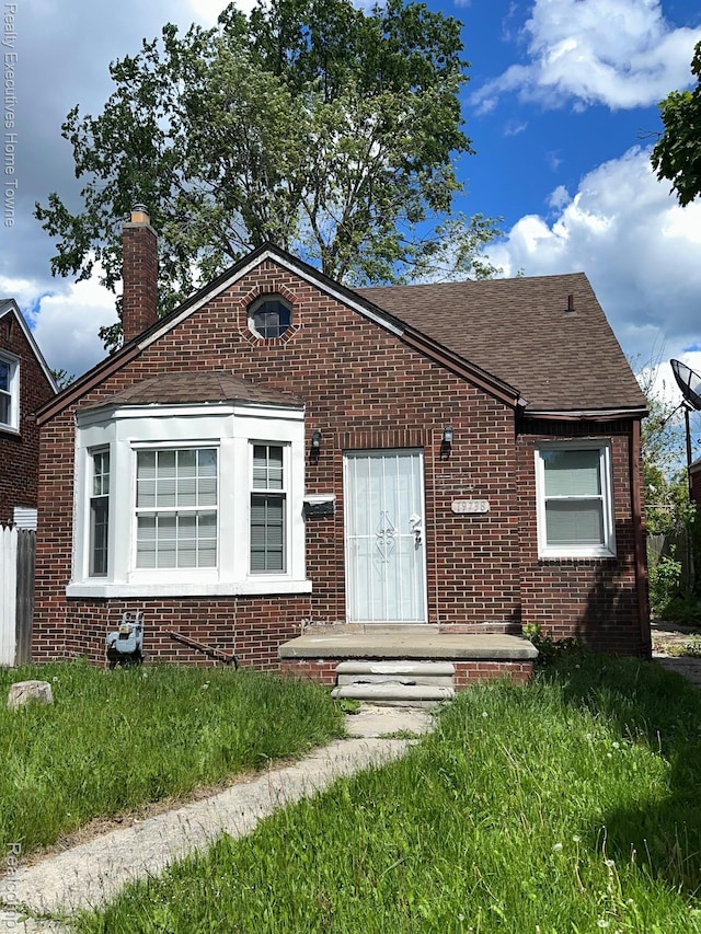 19738 Westphalia St, Detroit, MI 48205 - bungalow-style house with brick siding, a chimney, and roof with shingles