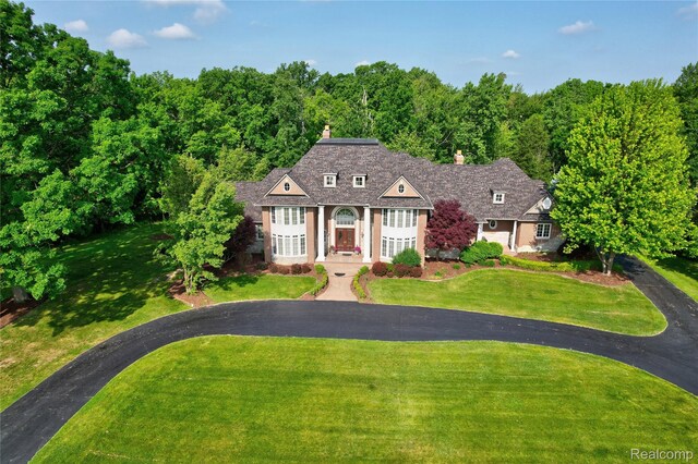 8356 Misty Mdws, Grand Blanc, MI 48439 - view of front of house with a front lawn, a chimney, and asphalt driveway