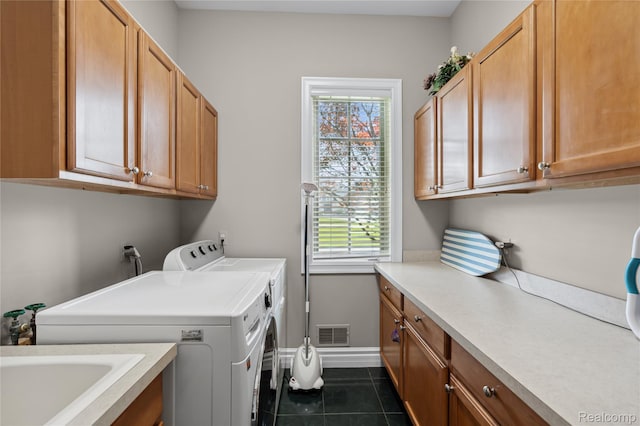 8356 Misty Mdws, Grand Blanc, MI 48439 - washroom featuring cabinet space, washer and clothes dryer, plenty of natural light, and dark tile patterned floors