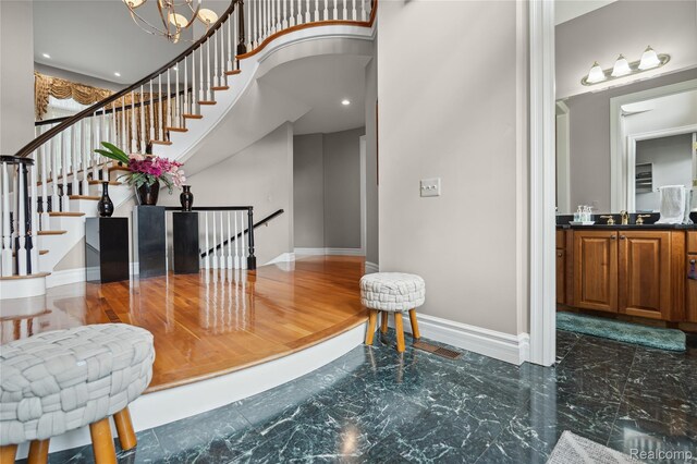 8356 Misty Mdws, Grand Blanc, MI 48439 - entrance foyer featuring marble tiled floors, a towering ceiling, and a chandelier