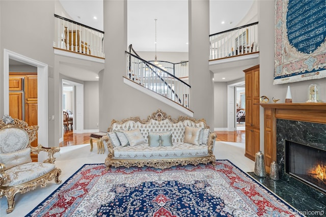 8356 Misty Mdws, Grand Blanc, MI 48439 - living room featuring a high ceiling, stairs, a fireplace, wood finished floors, and a chandelier