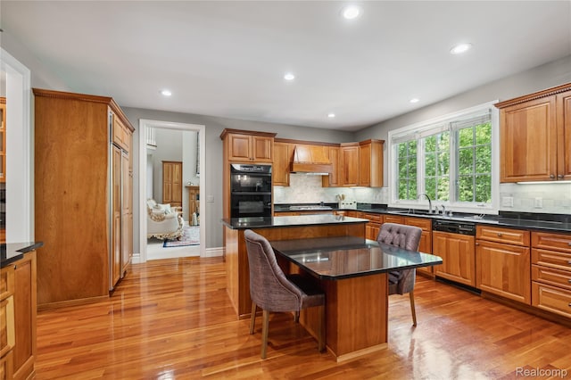 8356 Misty Mdws, Grand Blanc, MI 48439 - kitchen with paneled dishwasher, custom range hood, a breakfast bar area, light wood-type flooring, and tasteful backsplash