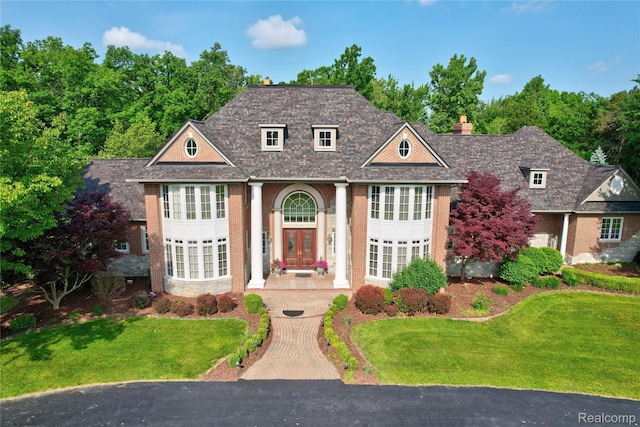 8356 Misty Mdws, Grand Blanc, MI 48439 - view of front of property featuring a front lawn, a chimney, brick siding, and french doors