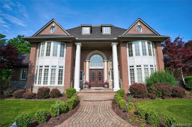 8356 Misty Mdws, Grand Blanc, MI 48439 - view of front facade with french doors, brick siding, roof with shingles, and a front lawn
