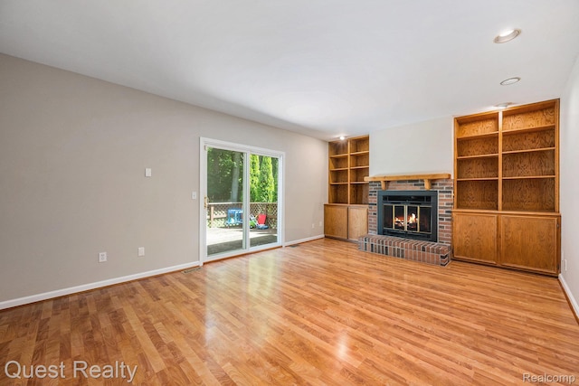 28041 Gettysburg St, Farmington, MI 48331 - unfurnished living room featuring a brick fireplace, light wood finished floors, built in features, and recessed lighting