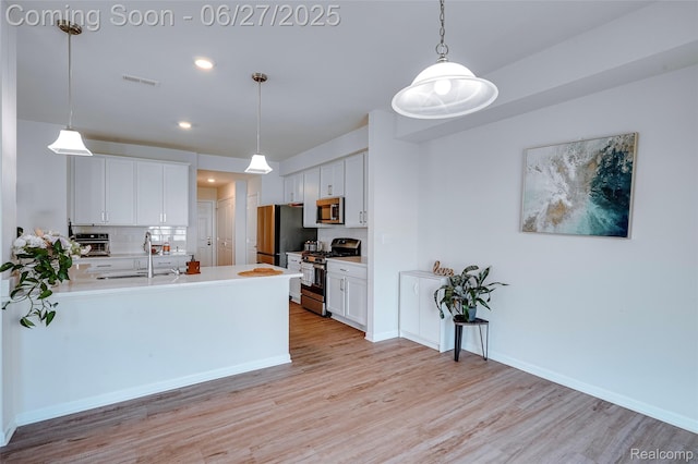 606 Angus Ln, Saline, MI 48176 - kitchen featuring stainless steel appliances, light wood-style floors, backsplash, white cabinets, and recessed lighting