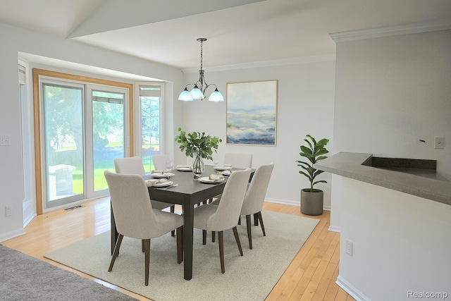 35260 Bradford Dr, New Baltimore, MI 48047 - dining space featuring light wood-style floors, ornamental molding, and a chandelier